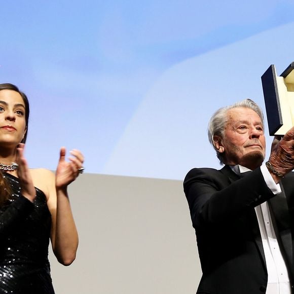 Alain Delon (avec un badge Paris Match d'une ancienne couverture du magazine titrant "Alain Delon, mes deux amours, Rosalie et Anouchka) et sa fille Anouchka (Robe Elie Saab) - Remise de la Palme d'Honneur à Alain Delon lors du 72ème Festival International du Film de Cannes. 19 mai 2019. 
© Jacovides-Moreau / Bestimage