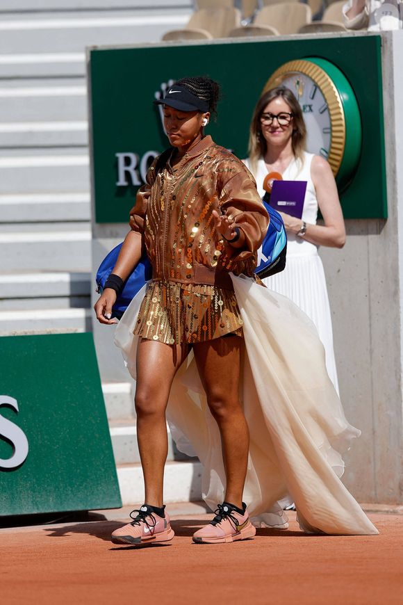 Interrogée par la journaliste Mary Patrux sur ses changements de tenues, Naomi Osaka a confié adorer "tenir les gens en haleine" et s'amuser des réactions du public.

Naomi Osaka arrive avec une traine blanche pour son second tour aux internationaux de France de Tennis de Roland Garros 2026, à Paris, France, le 28 mai 2026. © Imago/PsnewZ/Bestimage