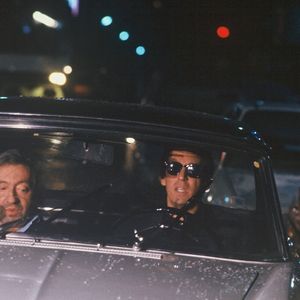Archives - Serge Gainsbourg et Thierry Ardisson en "peugeot 404 lors de l'émission "Lunettes noires pour nuits blanches" à Paris en 1989. (AGENCE / BESTIMAGE).
