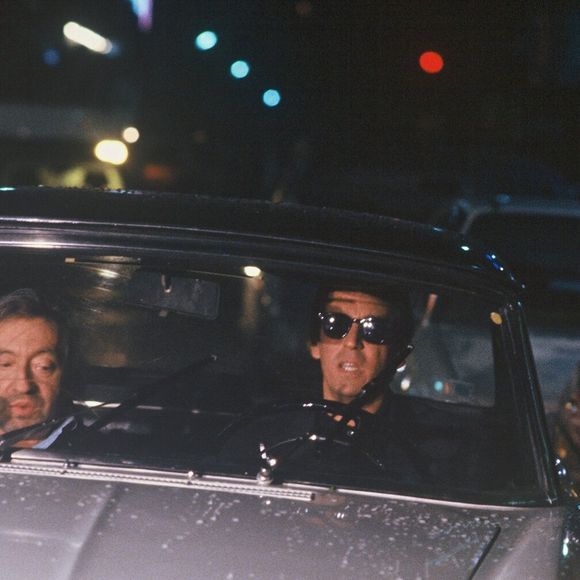 Archives - Serge Gainsbourg et Thierry Ardisson en "peugeot 404 lors de l'émission "Lunettes noires pour nuits blanches" à Paris en 1989. (AGENCE / BESTIMAGE).