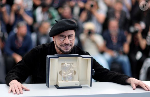 John Travolta pose avec sa Palme d'or d'honneur au photocall du film "Propeller One-Way Night Coach" lors du 79ème Festival International du Film de Cannes, France, le 16 mai 2026. © Jacovides-Moreau/bestimage