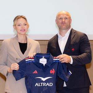 La princesse Charlène de Monaco se voit offrir un maillot dédicacé par les joueurs du XV de France de rugby, vainqueurs du tournoi des 6 nations 2025, des mains de William Servat, l'entraîneur du XV de France - La princesse C.de Monaco, en compagnie de son frère G.Wittstock, participe à la remise des prix de la "Journée du respect" au collège Charles III à Monaco, le 29 avril 2025. © Olivier Huitel / Pool Monaco / Bestimage