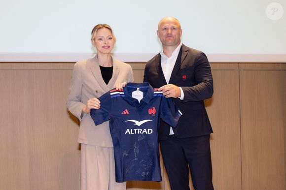 La princesse Charlène de Monaco se voit offrir un maillot dédicacé par les joueurs du XV de France de rugby, vainqueurs du tournoi des 6 nations 2025, des mains de William Servat, l'entraîneur du XV de France - La princesse C.de Monaco, en compagnie de son frère G.Wittstock, participe à la remise des prix de la "Journée du respect" au collège Charles III à Monaco, le 29 avril 2025. © Olivier Huitel / Pool Monaco / Bestimage