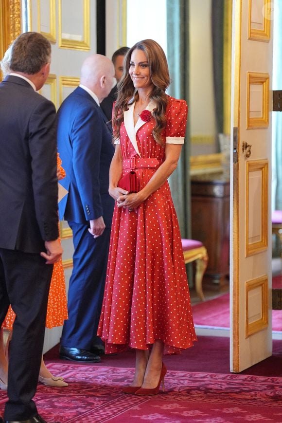 Côté accessoires, elle avait opté pour un sac Miu Miu en daim rouge, assorti à des escarpins de la même couleur, signé Gianvito Rossi.

La princesse de Galles lors d'une réception organisée par Cancer Research UK à l'occasion du 125e anniversaire de l'organisation caritative, au St James's Palace, à Londres. 

©Bestimage