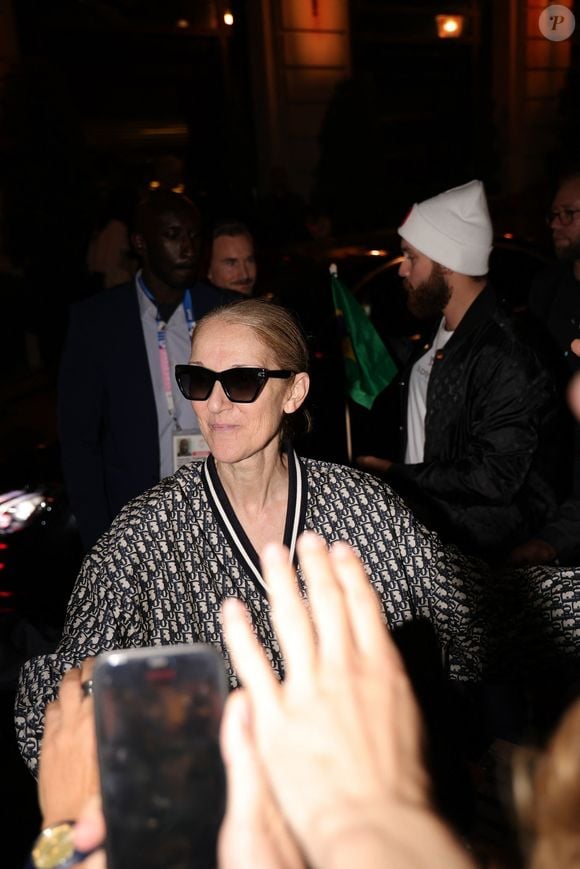 Paris, FRANCE  - Celine Dion in full Dior creates a crowd movement as she exits through the roof of her car leaving her hotel in Paris followed by her fans



Pictured: Celine Dion