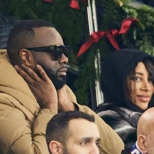 Gims et sa femme DemDem dans les tribunes du match de Ligue 1 McDonald's opposant le Paris Saint-Germain (PSG) à Lyon (3-1) au Parc des Princes à Paris le 15 décembre 2024. © Cyril Moreau/Bestimage