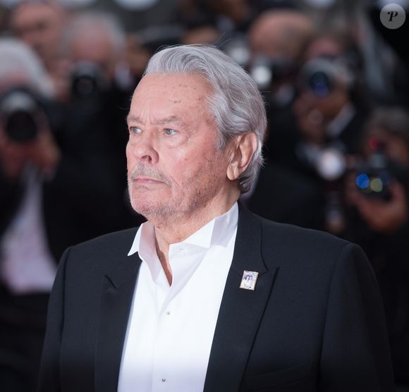 Alain Delon (Palme d'Or d'Honneur du 72ème festival de Cannes avec un badge Paris Match d'une ancienne couverture du magazine titrant "Alain Delon, mes deux amours, Rosalie et Anouchka) - Montée des marches du film "A Hidden Life" lors du 72ème Festival International du Film de Cannes. Le 19 mai 2019 (Backgrid UK/ Bestimage).