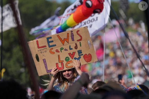 Un fan dans la foule tient une pancarte, tout en regardant Lewis Capaldi se produire sur la scène Pyramid pendant le festival de Glastonbury à Worthy Farm dans le Somerset. Date de la photo : Vendredi 27 juin 2025. Yui Mok/PA Wire.