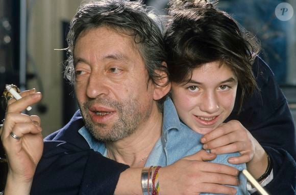 En France, à Paris, Serge Gainsbourg chez lui avec sa fille Charlotte dans son hôtel particulier de la rue de Verneuil, posant au milieu de son bric-à-brac où il entasse des objets hétéroclites en mai 1985.  © Michel Marizy via Bestimage