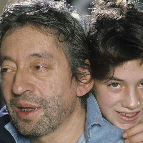 En France, à Paris, Serge Gainsbourg chez lui avec sa fille Charlotte dans son hôtel particulier de la rue de Verneuil, posant au milieu de son bric-à-brac où il entasse des objets hétéroclites en mai 1985.  © Michel Marizy via Bestimage