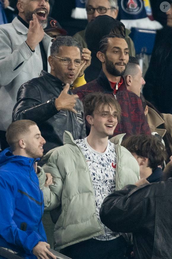 Roschdy Zem et son fils Chad Zem, Michou - Célébrités des les tribunes lors du match aller du quart de finale de Ligue des champions entre le PSG et Aston Villa (3-1) au Parc des Princes à Paris le 9 avril 2025. © Cyril Moreau/Bestimage