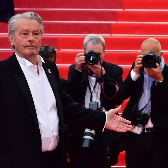 C'est Brigitte Auber qui a bouleversé le destin de la future star des salles obscures : plutôt que de le laisser sombrer dans des sales coups, elle l'a poussé à faire du septième art son métier. Et elle a eu raison : Alain Delon est devenu l'un des chouchous du cinéma. 

Alain Delon - Montée des marches du film "A Hidden Life" lors du 72ème Festival International du Film de Cannes. Le 19 mai 2019 © Rachid Bellak/ Bestimage