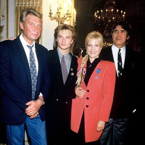 Celui qui a élevé David Hallyday comme son propre fils et qui est marié depuis plus de quarante ans avec Sylvie Vartan a joué un rôle capital dans le destin d'une série culte...

Johnny Hallyday, David Hallyday, Tony Scotti et Sylvie Vartan qui reçoit la médaille de l'ordre national du mérite, France, le 14/11/1987. Crédit Bertrand Rindoff Petroff / Bestimage