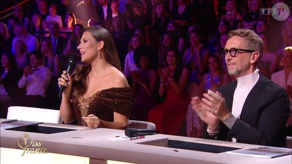 Parmi les membres du jury, Camille Cerf, Miss France 2015, a particulièrement retenu l’attention grâce à sa robe dorée à paillettes signée Nicolas Fafiotte. 

Miss France 2026. Caputure d'écran TF1