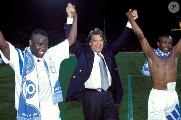 C'est lui qui en 1993, inscrit le but victorieux qui permet à Tapie et son équipe de lever la coupe des Champions.

archives - Joy Basile Boli (OM) / Bernard Tapie (OM PDT) / Abedi Pele (OM) - football - champions league 1992/93 - final - Milan AC v Olympique Marseille
© DPPI / Panoramic / Bestimage