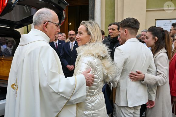 Céline Olive (fille de E.Leclercq) et son fils Benjamin costume crème (petit-fils de E.Leclercq) avec le prêtre à la sortie des obsèques d'Evelyne Leclercq en la cathédrale Sainte-Réparate de Nice, France, le 13 janvier 2026. Une tenue blanche ou claire est souhaitée pour la cérémonie. Ni fleurs, ni couronnes. Selon la volonté de la défunte Evelyne, des dons en faveur du pôle cancérologie Arnault Tzanck pourront être effectués par chèque à l'ordre de FDD AAT ou via un lien numérique HelloAsso - Campagne de dons, Institut du Cancer de Mougins. © Bruno Bebert/Bestimage