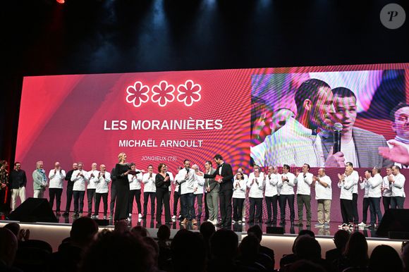 Fait amusant souligné par la presse : ce nouveau roi des fourneaux fuit tellement la lumière qu'il ne possède ni compte Instagram, ni même une page Wikipédia !

Le chef Michaël Arnoult avec sa femme Ingrid, récompensé avec une troisème étoile pour son restaurant "Les Morainières" entourés par tous les chefs triplement étoilés de France et Monaco - Cérémonie des remises des Etoiles Michelin 2026 au Grimaldi Forum à Monaco le 16 mars 2026. 1 étoile, 7 nouveaux 2 étoiles et 1 nouveau 3 étoiles pour l'édition 2026 © Bruno Bebert/Bestimage
