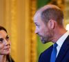 Kate, passionnée et absorbée par la discussion, ralentissait le rythme de l’événement. William est alors intervenu avec délicatesse, posant sa main sur son dos pour guider subtilement sa femme.

Le William, prince de Galles, et Catherine (Kate) Middleton, princesse de Galles, contemplent la "Collection Royale" dans le Salon Vert du château de Windsor, dans le cadre de leur visite officielle au Royaume-Uni. Windsor, le 3 décembre 2025.

Hannah McKay/WPA-Pool/Julien Burton via Bestimage