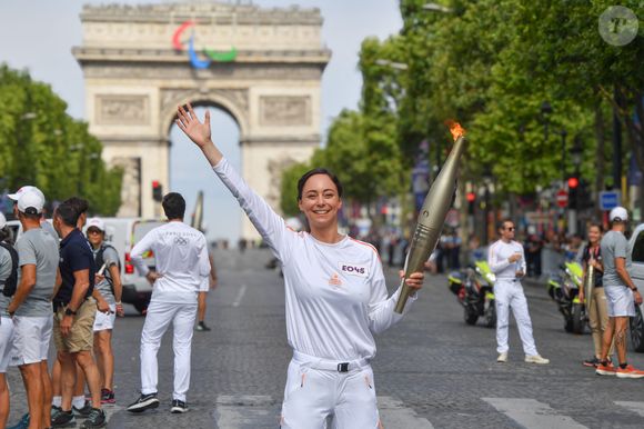 Amir et Nina Métayer lors du relais de la Flamme Olympique sur les Champs-Elysées à Paris, le 15 juillet 2024. @Alexandre Fay / PixPlanete / Bestimage