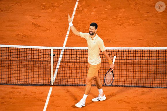 Pour cette édition 2026, la marque au crocodile et plus précisément Pelagia Kolotouros, directrice artistique de la Maison, a justement imaginé pour Novak Djokovic une veste sur-mesure au concept audacieux : se fondre littéralement dans ce qui fait la renommée du tournoi.

Novak Djokovic (SRB) - Internationaux de France de Tennis de Roland Garros 2026 le 24 mai.