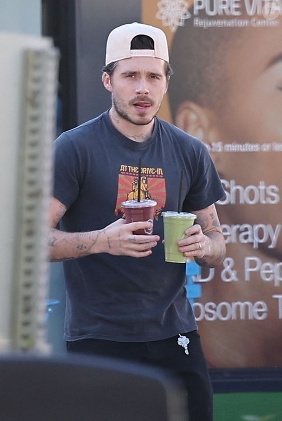 Brooklyn Beckham sort du Earth Bar à Los Angeles, portant deux boissons lors d'une sortie matinale décontractée. @Backgrid USA / Bestimage