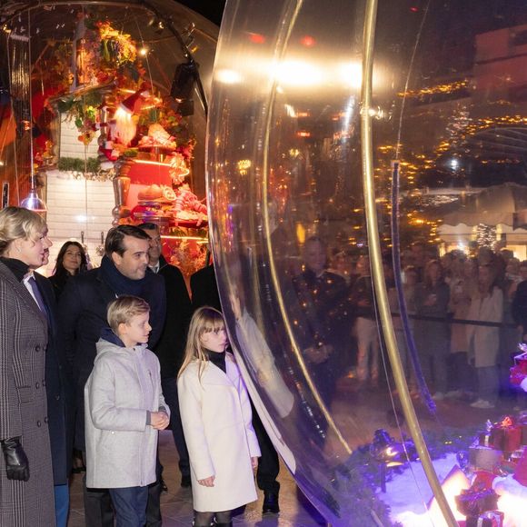 Le prince Albert II de Monaco et la princesse Charlène, avec leurs enfants, les jumeaux princiers, Jacques et Gabriella, ont donné le coup d'envoi des illuminations de la SBM, sur la Place du Casino de Monaco, le 30 novembre 2024. 
C'est sous le regard de leurs parents, du ministre d'Etat, Didier Guillaume, et de Stéphane Valeri, le président-délégué de la Société des Bains de Mer, que le prince héréditaire Jacques et sa soeur la princesse Gabriella, ont appuyé sur le buzzer déclenchant ainsi l'allumage des décors de la Place.
Les boules à neige géantes sont installées sur la place avec un tout nouveau décor animé dédié aux "moments magiques de Noël". Calendrier de l’Avent, décoration du sapin, repas de fête, douce nuit de Noël ou encore la découverte des cadeaux sont mis en scène et en musique dans chacune des cinq boules disposées autour du sapin de 18mètres de haut. © Olivier Huitel/Pool Monaco/Bestimage