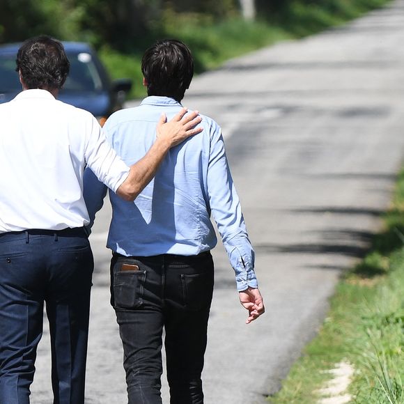 Anthony Delon et son demi-frère Alain-Fabien découvrent les hommages devant les grilles de la propriété de Douchy, quelques heures avant les obsèques de leur père, A.Delon, le 24 août 2024.  © Agence / Bestimage