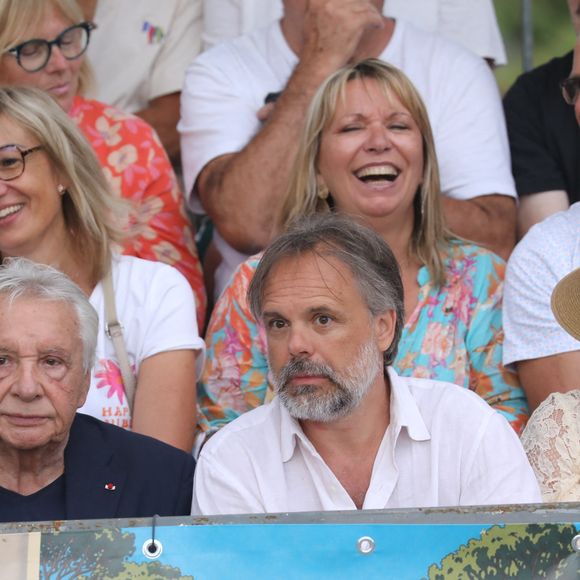 Semi-exclusif - Michel Sardou et sa femme Anne-Marie Périer, Romain Sardou et sa compagne Kym Thiriot enceinte - Michel Sardou rend hommage à son père en famille lors du premier trophée de pétanque "Fernand Sardou" à Bormes-les-Mimosas le 29 mai 2026. Le célèbre chanteur est venu en famille avec sa femme, son fils Romain avec son fils de deux ans et demi et de sa compagne enceinte de son deuxième enfant.
La première édition du Trophée Fernand Sardou est organisée du 29 au 31 mai au coeur du village de Bormes les Mimosas. Une initiative portée par Michel et son fils Romain, pour rendre hommage à leur illustre parent Fernand Sardou au travers d'un tournoi de pétanque.
En lien avec la municipalité et l'Amicale Bouliste Borméenne (ABB), un premier Trophée Fernand Sardou sera organisé avec deux grands temps forts : Le vendredi, dès 18h, un tournoi d'exhibition sera proposé et verra s'affronter 16 triplettes. Puis un concours fédéral à pétanque sera organisé le weekend et ouvert à tous les amateurs. 128 équipes seront réparties sur les sites les plus emblématiques du village, à savoir au boulodrome de la place Saint-François, mais aussi au parc Cigalou, sur le site du château et à l'ancien stade. © Franz Chavaroche/Bestimage
