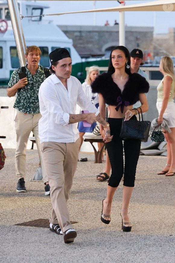 Brooklyn Beckham (avec un look Caligae et chaussettes blanches) et sa femme Nicola Peltz se promènent sur le port de Saint-Tropez, le 18 juillet 2025 @Backgrid USA / Bestimage