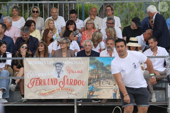 Semi-exclusif - Michel Sardou et sa femme Anne-Marie Périer, Romain Sardou et sa compagne Kym Thiriot enceinte - Michel Sardou rend hommage à son père en famille lors du premier trophée de pétanque "Fernand Sardou" à Bormes-les-Mimosas le 29 mai 2026. Le célèbre chanteur est venu en famille avec sa femme, son fils Romain avec son fils de deux ans et demi et de sa compagne enceinte de son deuxième enfant.
La première édition du Trophée Fernand Sardou est organisée du 29 au 31 mai au coeur du village de Bormes les Mimosas. Une initiative portée par Michel et son fils Romain, pour rendre hommage à leur illustre parent Fernand Sardou au travers d'un tournoi de pétanque.
En lien avec la municipalité et l'Amicale Bouliste Borméenne (ABB), un premier Trophée Fernand Sardou sera organisé avec deux grands temps forts : Le vendredi, dès 18h, un tournoi d'exhibition sera proposé et verra s'affronter 16 triplettes. Puis un concours fédéral à pétanque sera organisé le weekend et ouvert à tous les amateurs. 128 équipes seront réparties sur les sites les plus emblématiques du village, à savoir au boulodrome de la place Saint-François, mais aussi au parc Cigalou, sur le site du château et à l'ancien stade. © Franz Chavaroche/Bestimage