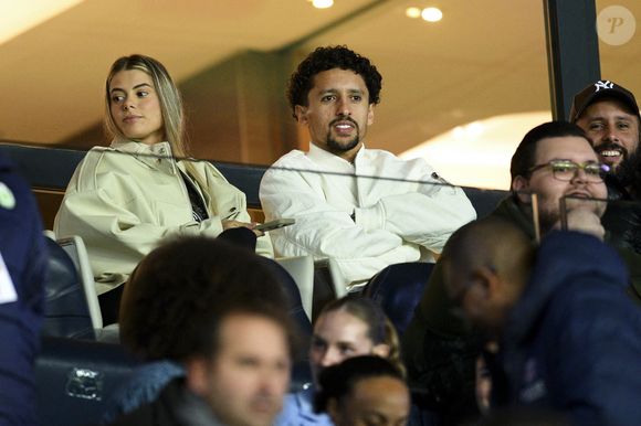 Marquinhos et sa femme Carol Cabrino assistent au quart de finale du match aller de Ligue des champions entre les équipes féminines du Paris Saint-Germain et du VfL Wolfsburg (0-1) au Parc des Princes à Paris le 22 mars 2023.