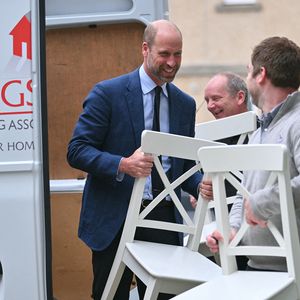 Par ces gestes concrets, il affiche une monarchie plus proche du terrain et des citoyens.

Le prince William aide un locataire à transporter des meubles dans son nouvel appartement lors d'une visite à l'association de logement social Langstane, à Aberdeen le 30 juin 2026.
Andy Buchanan/WPA-Pool/Julien Burton/ Bestimage