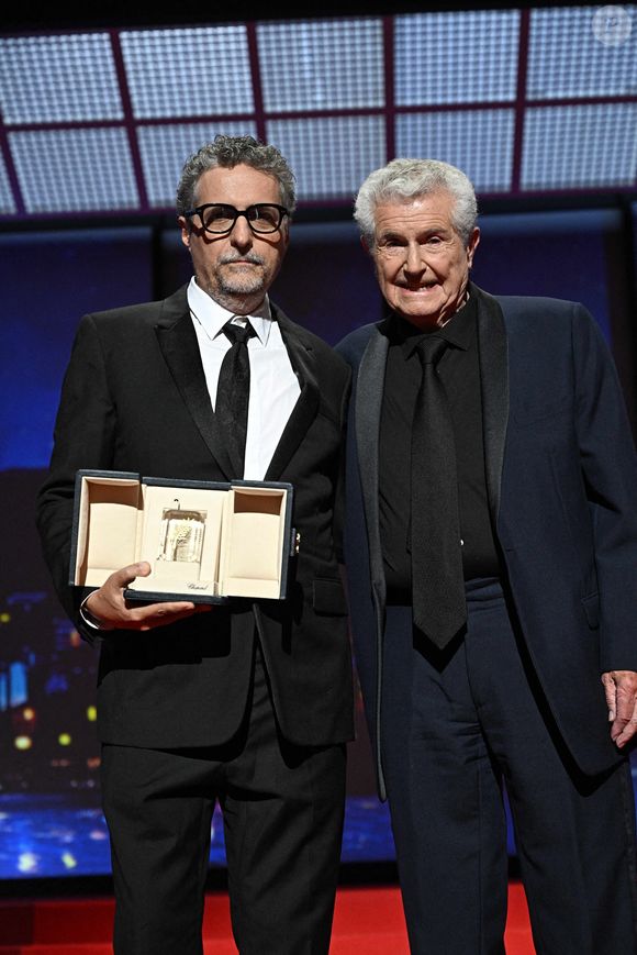 Le réalisateur brésilien Kleber Mendonca Filho reçoit le prix du meilleur réalisateur et est accompagné par le réalisateur français Claude Lelouch pour le film "O Agente Secreto" (L'agent secret) du réalisateur français Claude Lelouch lors de la cérémonie de clôture de la 78e édition du Festival de Cannes à Cannes, dans le sud de la France, le 24 mai 2025.  Niviere David/ABACAPRESS.COM