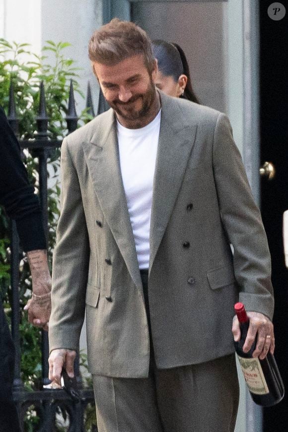 Exclusif - La famille Beckham (David Beckham, sa femme Victoria, Cruz Beckham, sa compagne Jackie Apostel, Roméo Beckham, sa compagne Kim Turnbull et Harper Seven) arrive à son hôtel fétiche "La Réserve" pour fêter les 50 ans de David Beckham (2 mai 1975) à Paris, France, le 2 mai 2025. David sort avec une bouteille de rouge pétrus Pomerol (surement l'année de sa naissance) à la main . © Bestimage