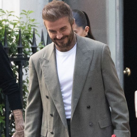 Exclusif - La famille Beckham (David Beckham, sa femme Victoria, Cruz Beckham, sa compagne Jackie Apostel, Roméo Beckham, sa compagne Kim Turnbull et Harper Seven) arrive à son hôtel fétiche "La Réserve" pour fêter les 50 ans de David Beckham (2 mai 1975) à Paris, France, le 2 mai 2025. David sort avec une bouteille de rouge pétrus Pomerol (surement l'année de sa naissance) à la main . © Bestimage