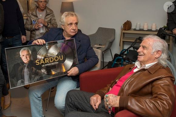 Exclusif  - Michel Sardou pose avec son double disque de platine devant Jean-Paul Belmondo - People au concert ultime de Michel Sardou pour la dernière date de son spectacle "La dernière danse" à la Seine Musicale à Boulogne-Billancourt le 11 avril 2018. Le chanteur a rassemblé plus de 400 000 spectateurs pour une tournée de 82 concerts.  © Pierre Perusseau/Bestimage