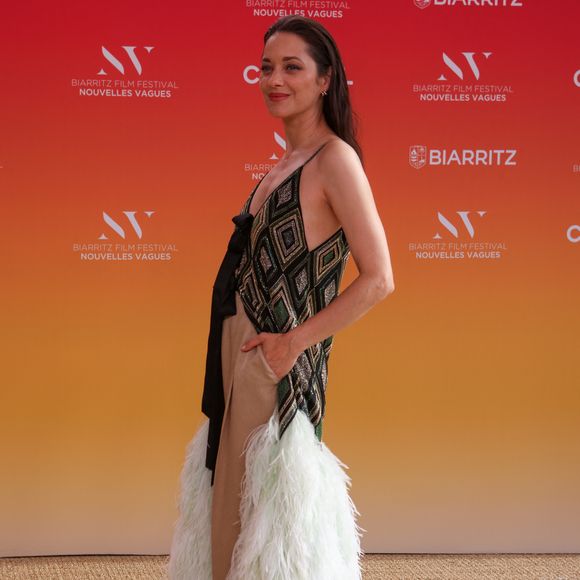 Cette pièce brodée et ornée de plumes a nécessité plus de 430 heures de travail.

Marion Cotillard au Théâtre de la Gare du Midi lors de la Cérémonie d'ouverture du Festival international du film de Biarritz - Nouvelles Vagues 2026, le 23 juin 2026.  © Jean-Marc Lhomer / Bestimage