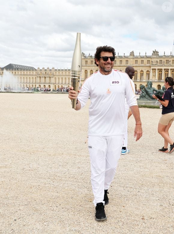 Le chanteur et acteur Patrick Bruel porteur de la flamme olympique des Jeux Olympiques de Paris 2024 (JO) au château de Versailles dans les Yvelines, France, le 23 juillet 2024. © Dominique Jacovides/Bestimage