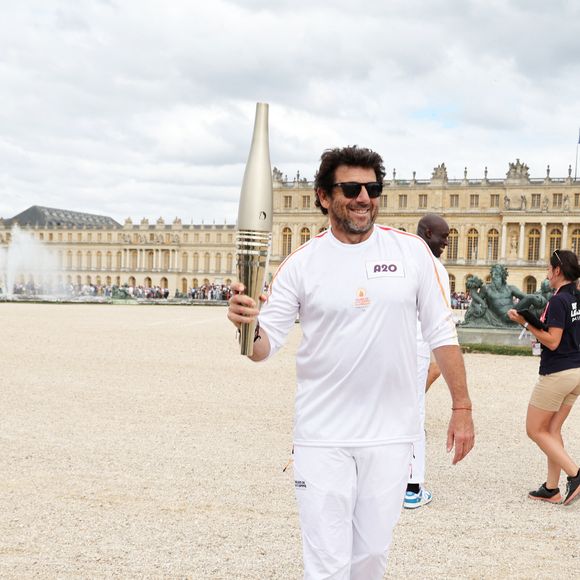 Le chanteur et acteur Patrick Bruel porteur de la flamme olympique des Jeux Olympiques de Paris 2024 (JO) au château de Versailles dans les Yvelines, France, le 23 juillet 2024. © Dominique Jacovides/Bestimage