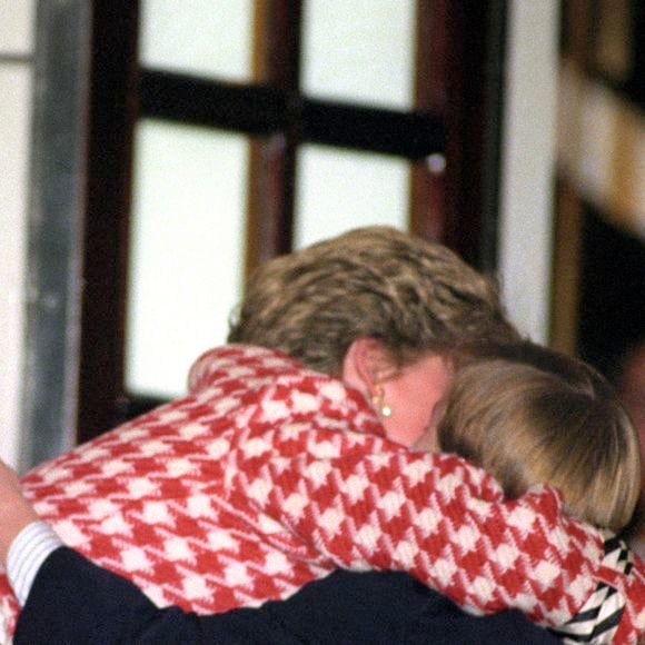 La Princesse de Galles serrant dans ses bras son fils aîné, le Prince William, alors âgé de 10 ans, après avoir embarqué sur le Royal Yacht Britannia avec son mari, le Prince de Galles et son fils cadet, le Prince Harry, le 23 octobre 1991.