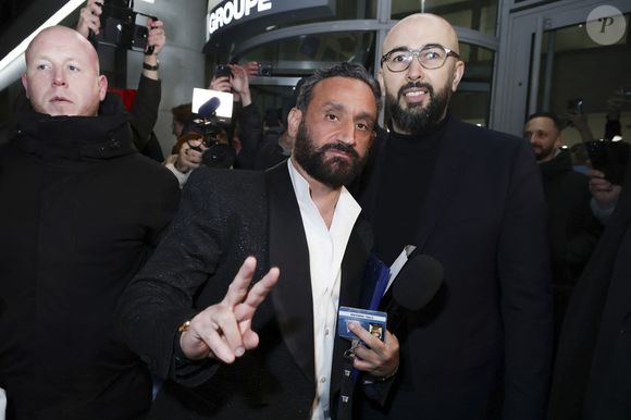 Exclusif - Cyril Hanouna se fait remettre son bagde de collaborateur du Groupe M6 par un des responsables de la sécurité - Les chroniqueurs et les invités quittent la dernière émission "Touche pas à mon poste" (TPMP) en bus pour se rendre devant le siège du groupe M6 à Neuilly-sur-Seine le 27 février 2025. © Jack Tribeca/Bestimage