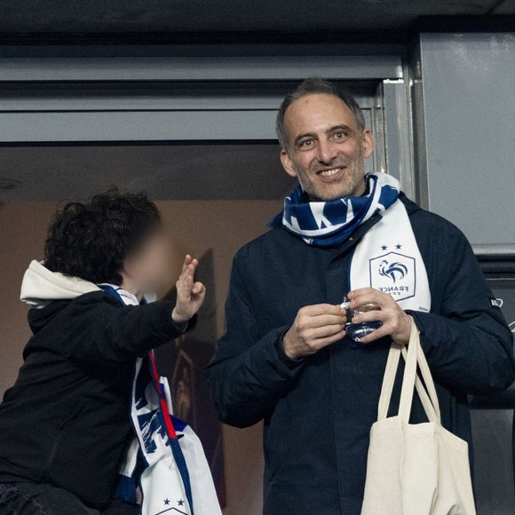 Raphaël Glucksmann et son fils - Célébrités dans les tribunes du quart de finale de la Ligue des Nations de l'UEFA 2025 "France - Croatie (2-0 / tab 5-4)" au Stade de France à Saint-Denis le 23 mars 2025. © Cyril Moreau/Bestimage