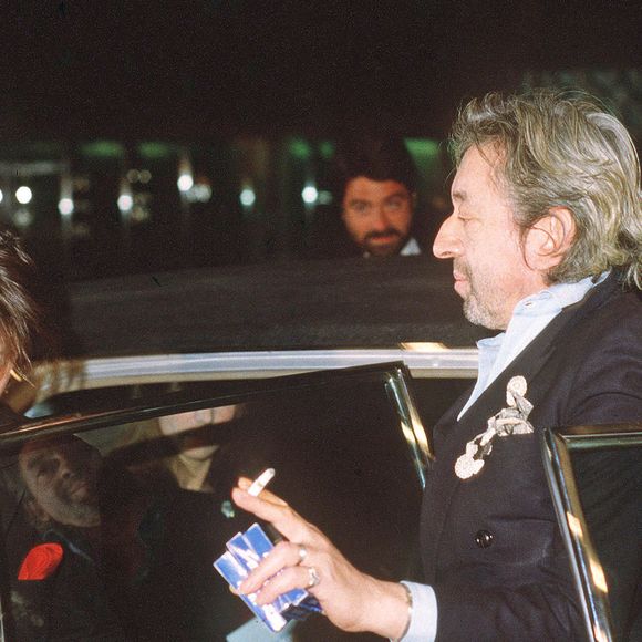 Le chanteur français Serge Gainsbourg accompagne sa fille Charlotte à la cérémonie des César en 1986 à Paris, en France, où elle a remporté le prix de la meilleure jeune actrice. Gainsbourg avait sur lui trois paquets de ses légendaires cigarettes Gitane. Photo de Christophe Geyres/ABACAPRESS.COM