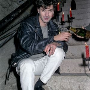 Reims 51) : Caves Ruinart. Etienne Daho assis sur les escaliers se faisant servir un verre de champagne en 1986. - Photo by Jolyot M/ANDBZ/ABACAPRESS.COM - Art Culture Spectacle ; Chanteur ; Chanteurs ; Musique ; Portrait ; Portraits ; Prise de vue ; Prises de vues