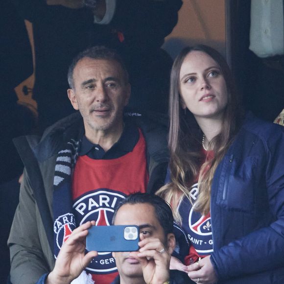 Elie Semoun et Aude Fraineau dans les tribunes de la demi-finale retour de Ligue des champions au Parc des Princes à Paris, le 7 mai 2024. 

Photo : Cyril Moreau / Bestimage