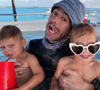 Au premier plan, les jumeaux Nicholas et Lucy enlacent tendrement le petit dernier de la fratrie.

Enrique Iglesias et ses jumeaux Nicholas et Lucy, en juillet 2021 sur Instagram.

Photo : Instagram