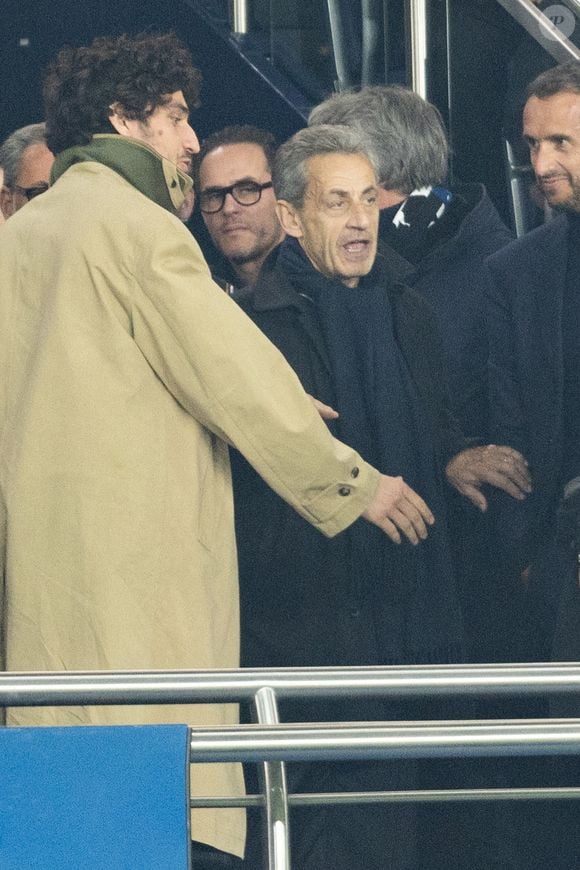 Louis Garrel, Nicolas Sarkozy - Célébrités dans les tribunes du match de 8ème de finale aller de la Ligue Des Champions 2025-2026 (LDC) "PSG - Chelsea (5-2)" au Parc des Princes à Paris le 11 mars 2026. © Cyril Moreau/Bestimage