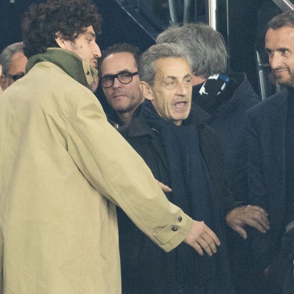 Louis Garrel, Nicolas Sarkozy - Célébrités dans les tribunes du match de 8ème de finale aller de la Ligue Des Champions 2025-2026 (LDC) "PSG - Chelsea (5-2)" au Parc des Princes à Paris le 11 mars 2026. © Cyril Moreau/Bestimage