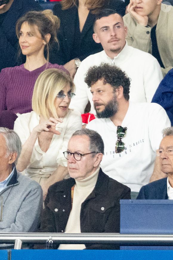 Ophélie Meunier, Michèle Laroque, Olivier Rosemberg, Robin Leproux  dans les tribunes du match de quart de finale aller de Ligue Des Champion au Parc des Princes à Paris, le 8 avril 2026. 

Photo : Cyril Moreau / Bestimage