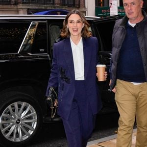 12/10/2024 Keira Knightley is pictured stepping out after a wardrobe change in New York City. The English actress carried a Chanel bag and wore a blue blazer, matching trousers, white blouse, and black shoes.